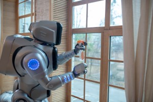 Doing housework. Big robot standing in the kitchen cleaning the window. AI use in the home. ChatGPT uses at home.