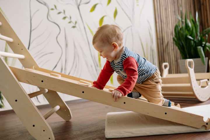 happy toddler climbing up a wooden ladder montessori climbing toys climbing frame