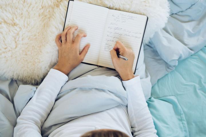 Woman journaling in bed