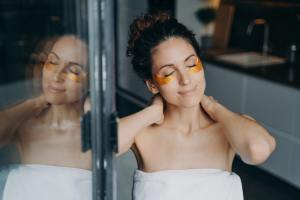 Beautiful woman with under eye patches enjoy morning skincare routine at home. Self love, self-care, self care for stay at home moms